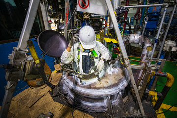Top view male worker climbs up the stairs into the tank carbon chemical grease area confined