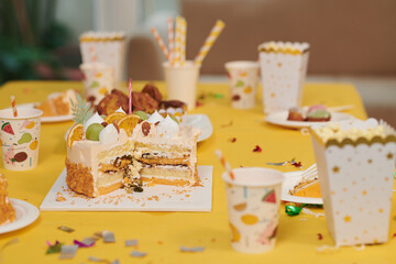 Cut birthday cake, drinks and sweets on table served for party guests