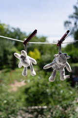 Children's soft toys hanging on a wire, drying in the sun, vertical format