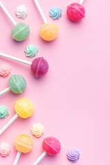 Sweet lollipops and candies on pink background