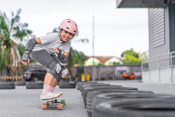 asian child skater or kid girl fun playing skateboard or smile riding carving surf skate on car...