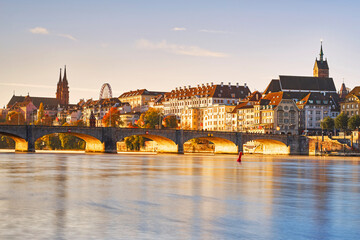 Frühmorgens in Basel bei der Mittleren Brücke. Kurz nach der blauen Stunde werden die Brückenbögen und die Altstadt von der Sonne angestrahlt - obrazy, fototapety, plakaty