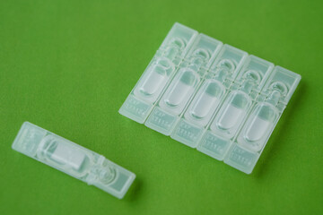 Single use artificial tear lubricant eye drops containers, tubes, isolated on green background....