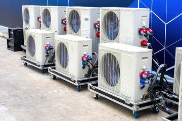 Portable air conditioners. Blocks of climatic equipment. External blocks of air conditioners on wheels. Cooling and purification technologies. Portable air conditioners near blue wall