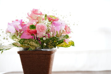 Fototapeta na wymiar 花、ピンクの花、フラワーアレンジメント、寄せ植え、カーテン、室内、バラ、カスミソウ、ピンク、白、グリーン、植木鉢、籠、可愛い、綺麗、ブーケ、お花