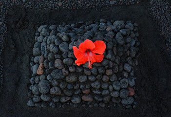 Stromboli, Steinhaufen am Strand aus Lavagestein symbolisiert die Vulkaninsel Stromboli. Die rote...