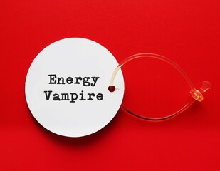 White tag on red background  with text written ENERGY VAMPIRE, means someone who intentionally...