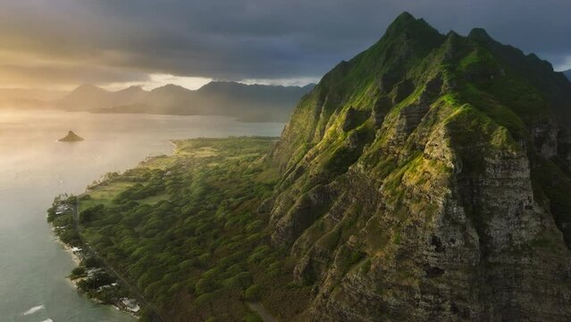 Cinematic Hawaii nature landscapes at golden sunrise. Scenic Oahu coast with beautiful ridges of volcanic mountains. Incredible scenery of green and weird-shaped peaks over ocean coast.Kualoa Ranch 4K