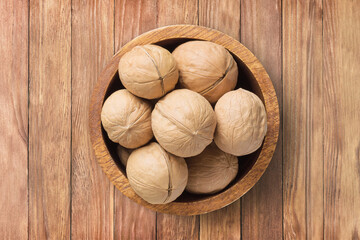 shelled walnut, chilean in bowl on wooden table background, top view. organic vegetarian food.