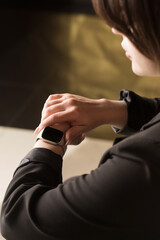 woman, office worker looking at smart watch, hands close-up, copy space