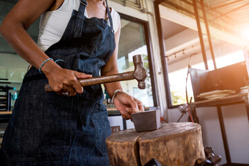 Young female jeweler making jewelry in workshop