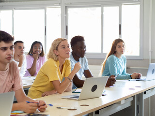 Group of diverse teen students in class listening to the lesson. High school, back to school