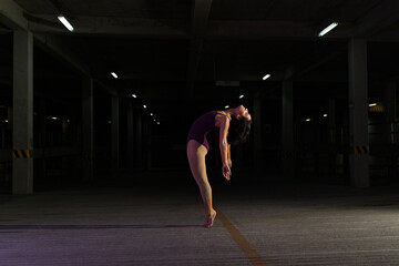Fototapeta na wymiar Cool modern female dancer performing at night in the street