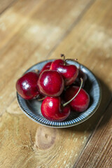 A few ripe cherry cherries in a blue saucer