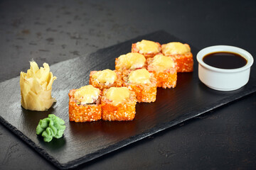 Tempura hot sushi rolls with salmon and tobico on dark background. Sushi menu. Japanese food.
