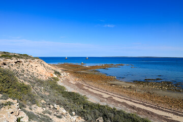 Rocky coastline beneath clear blue sky