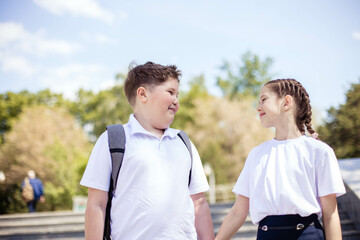 Close-up portrait of two cute teenagers with a school backpack, on the way to school