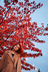 Portrait of beautiful red-haired woman merging with nature