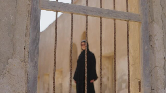 portrait of muslim woman nside prison metal bars and restriction of freedoms to women in the Middle East. 