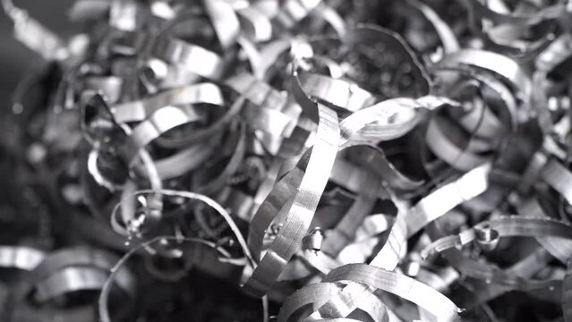 Steel scrap materials recycling. Aluminum chip waste after machining metal parts on a cnc lathe. Closeup twisted spiral steel shavings. Small roughness sharpness,