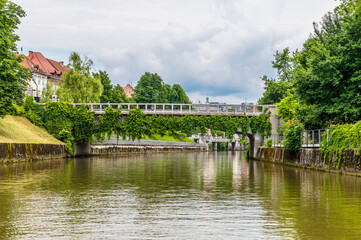 Fototapeta na wymiar A view on the Ljubljanica River towards the Saint James Bridge looking towards the center of Ljubljana, Slovenia in summertime