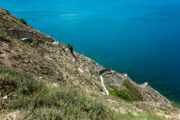 A large number of steep steps on the slope of a beautiful mountain to the sea. Tourism, travel and...