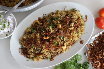 Mutton Biryani prepared with spices layered between mildly spiced ghee rice with a generous sprinkle of caramelized onions and Mutton marinated in yogurt