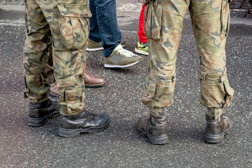 Two anonymous unrecognizable professional soldiers standing on the street, wearing traditional generic camo uniforms, legs closeup, camouflage. War, warfare, professional army simple abstract concept