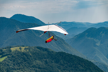 Vintage hang glider flies in the mountains - 621551148