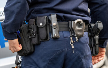 Policeman, police equipment utility belt with a gun, pepper spray and various accessories, detail shot, closeup seen from behind Police officer tools simple concept, emergency services job, occupation