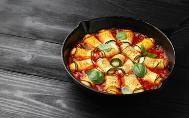 Baked zucchini rolls with ricotta, pecorino cheese in marinara sauce. Healthy food