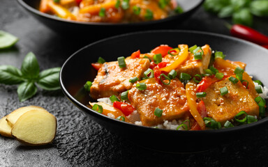 Homemade Stir Fry Tofu with Vegetables and Rice in black bowl.