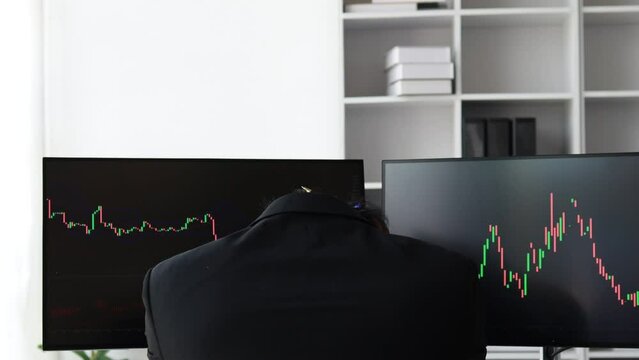 Man with computer screen showing stock chart, stock investor looking and analyzing stock chart and stressed as the stock is falling causing heavy losses.Investing in stocks concept. Cryptocurrencies.