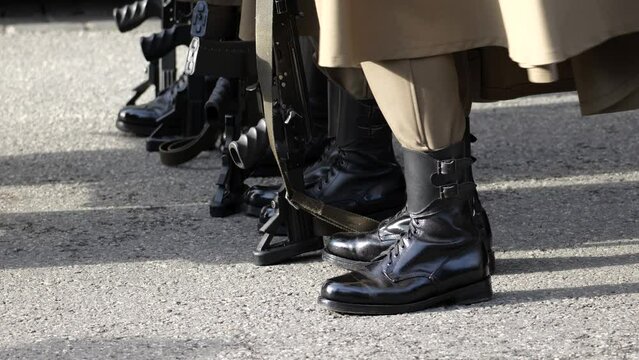 Poland, anonymous unrecognizable professional Polish army soldiers standing in row, line, holding machine guns. Boots, legs detail closeup, group of people, military representation parade concept