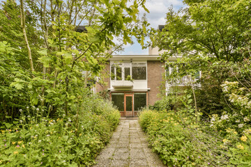 Fototapeta na wymiar a house surrounded by trees and plants in the middle section of an urban neighborhood, london, uk - stock photo