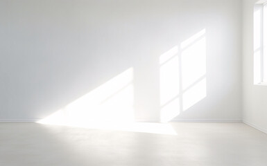 An empty room with a bright white wall and a window.