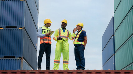 Foreman checking inventory or task details at Container cargo harbor. Logistics concept inside the...