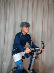 Senior man training on a fitness bike (exercise bike)