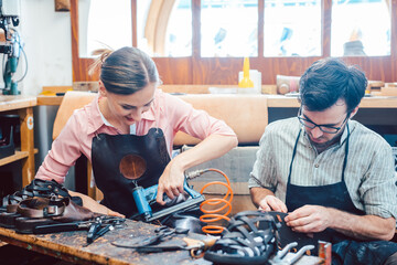 Woman and man shoemaker working together in the workshop