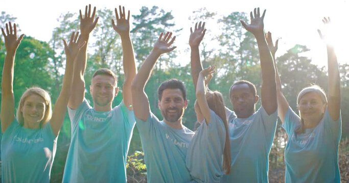 Group of dedicated volunteers concerned about global problem of pollution. Joyful multiracial activists, conservationists raising their hands to the sky. Environment protection. Ecological problems.