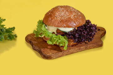 Grilled fresh burger with beef patty, tomatoes, cheese, cucumber and lettuce. On color.