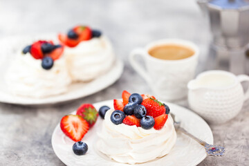 Delicious Pavlova meringue cake decorated with fresh strawberry and blueberry