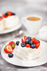 Delicious Pavlova meringue cake decorated with fresh strawberry and blueberry