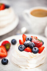 Delicious Pavlova meringue cake decorated with fresh strawberry and blueberry