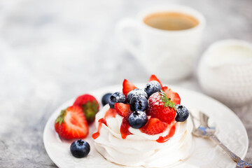 Delicious Pavlova meringue cake decorated with fresh strawberry and blueberry