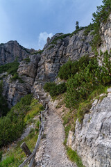 Fototapeta na wymiar Hiking trail with a wooden fence in the Italian Dolomites.Rocks, blue sky.