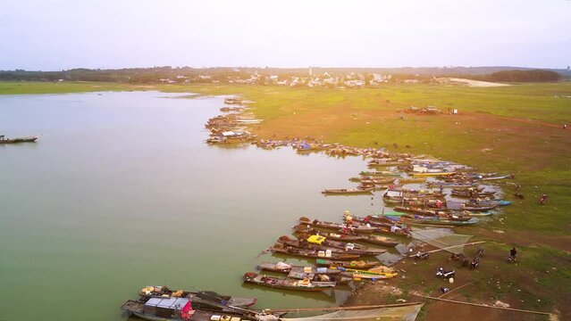 Aerial view of Ben Nom fishing village, a brilliant, fresh, green image of the green algae season on Tri An lake, with many traditional fishing boats anchored.