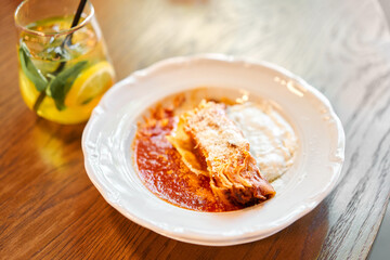Lasagna bolognese close up. Served traditional Italian cuisine. DIsh with pasta, meat, tomato sauce, grated cheese and basil leaves in plate. Italy culinary. Restaurant food portion, main course