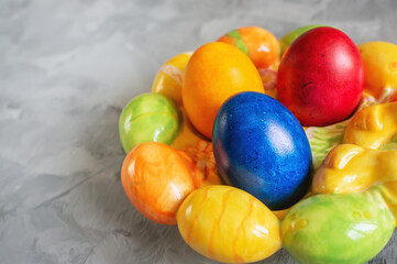 easter bright colored eggs in an Easter egg stand. Festive Easter multicolored eggs on a wooden background