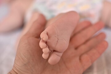 bare foot of a baby in a woman's palm